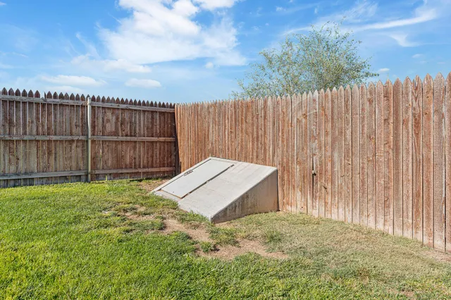 a view of a lake with a yard and potted plants