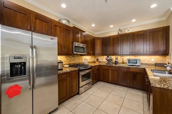 a kitchen with granite countertop stainless steel appliances cabinets a sink and a counter top space