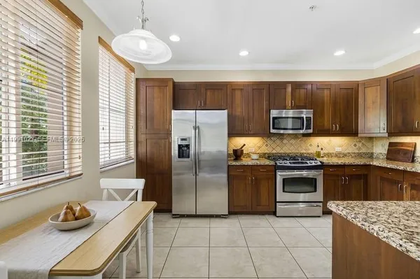 a kitchen with stainless steel appliances granite countertop a sink dishwasher stove top oven and refrigerator