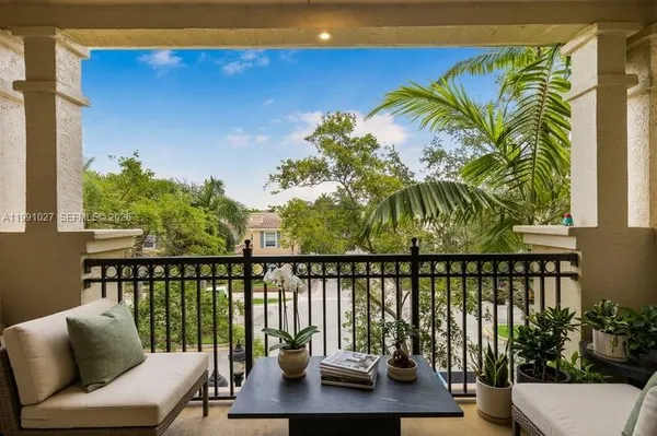 a balcony with couple of couch and potted plants