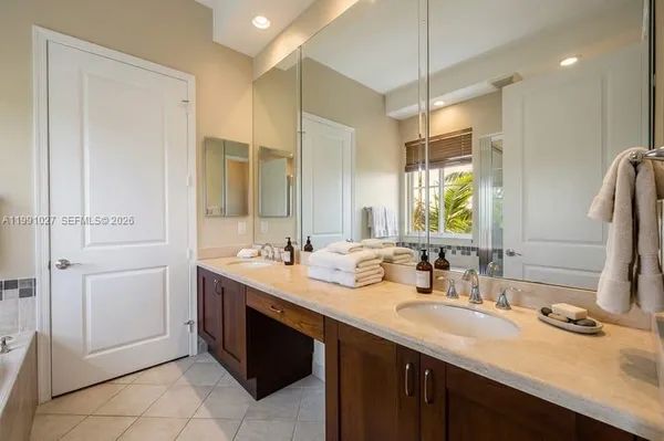 a bathroom with a double vanity sink a mirror and a shower