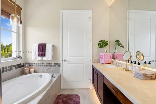 a bathroom with a tub sink and mirror