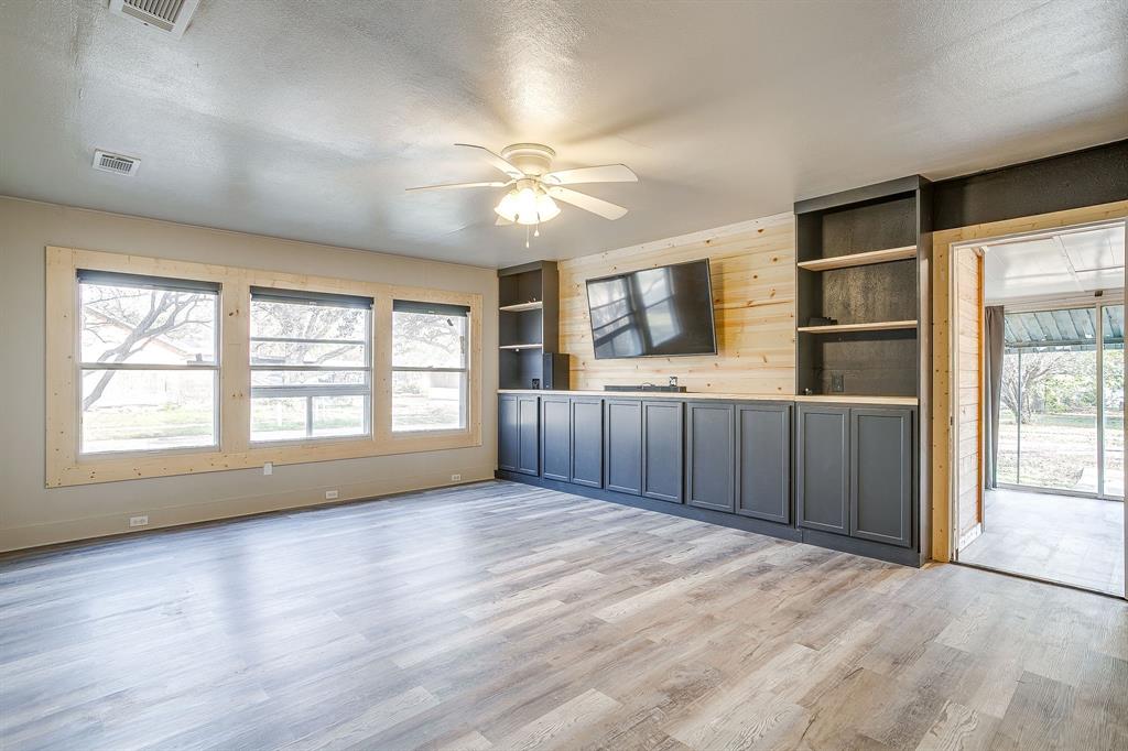 206 Bateman Street Meridian, TX 76665 - Photo 8 of 26 a view of an empty room with a window and wooden floor