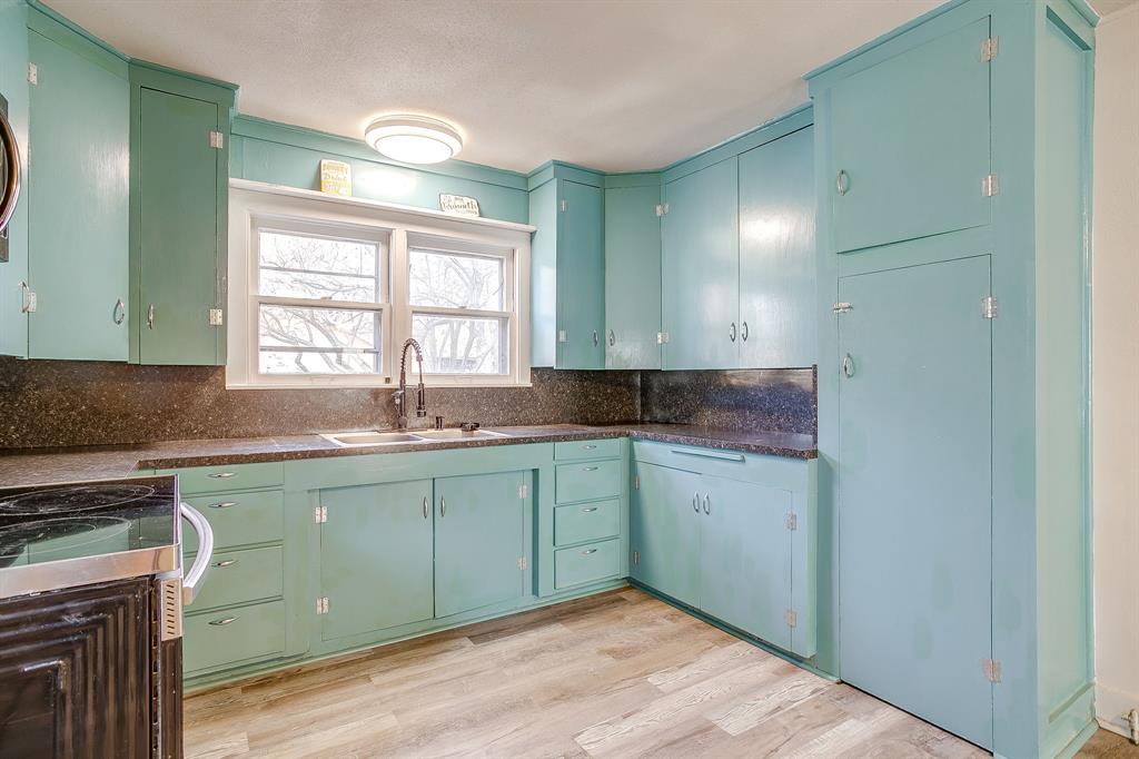 206 Bateman Street Meridian, TX 76665 - Photo 9 of 26 Kitchen featuring light wood-type flooring, range, decorative backsplash, and green cabinetry