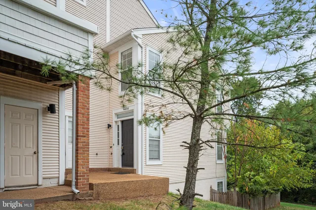 a front view of a house with a tree