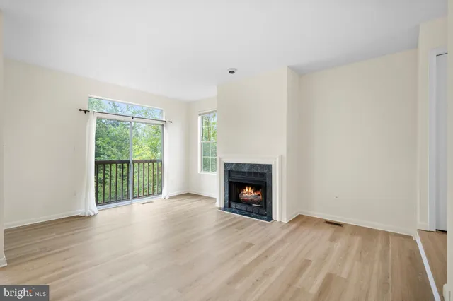 a view of empty room with wooden floor and fireplace