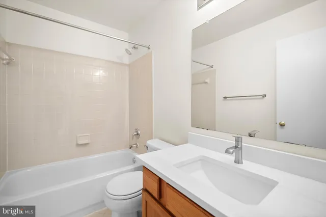 a bathroom with a sink a toilet and a large mirror