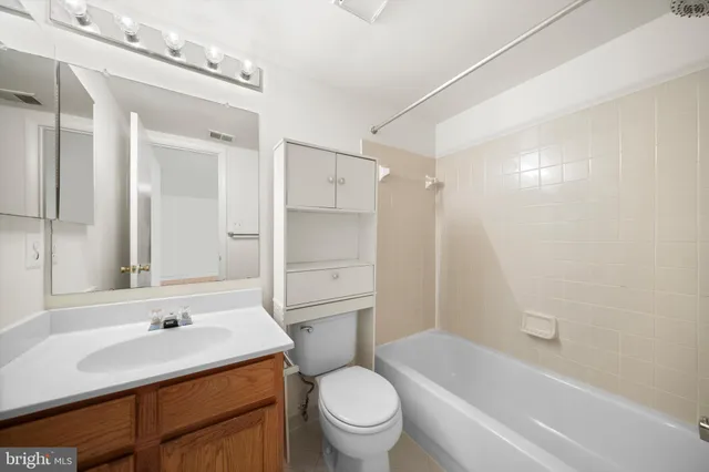 a bathroom with a sink a toilet and a large mirror