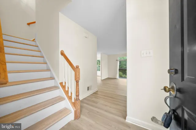 a view of a hallway with wooden floor and staircase