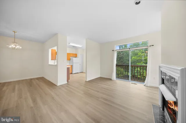 an empty room with wooden floor and fireplace