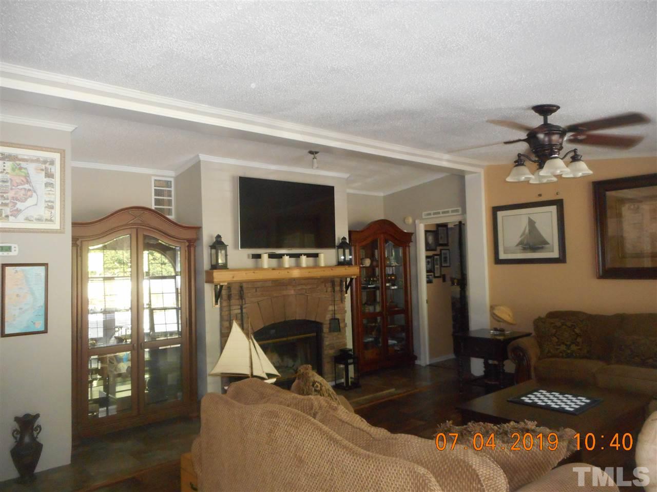 301 Mountain Ridge Road Rougemont, NC 27572 - Photo 11 of 22 a living room with furniture a flat screen tv and a fireplace