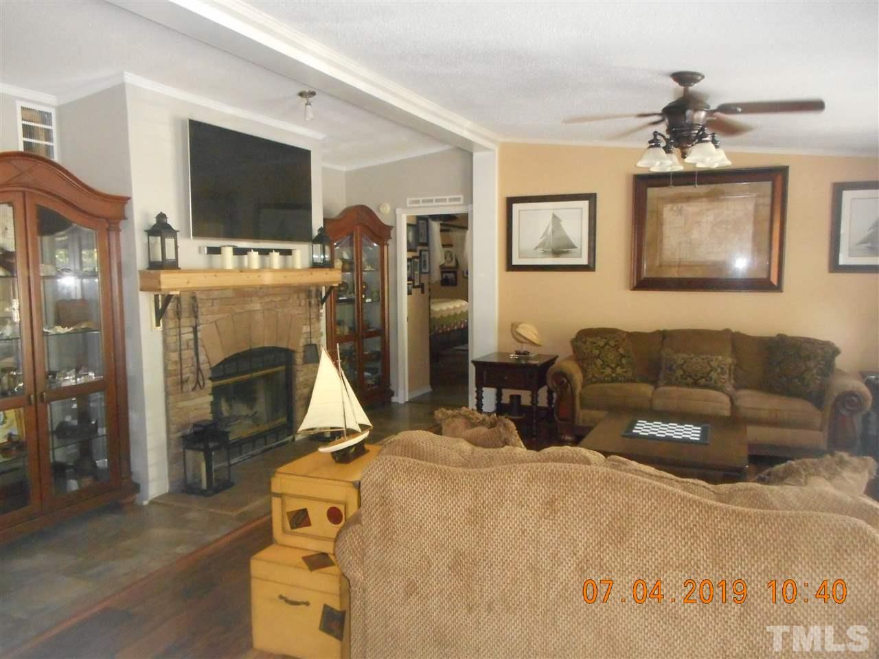 301 Mountain Ridge Road Rougemont, NC 27572 - Photo 10 of 22 a living room with furniture a flat screen tv and a fireplace