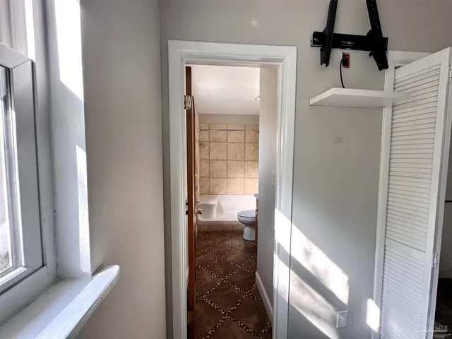 a view of a hallway with windows and cabinet