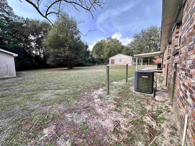 a backyard of a house with a table and chairs