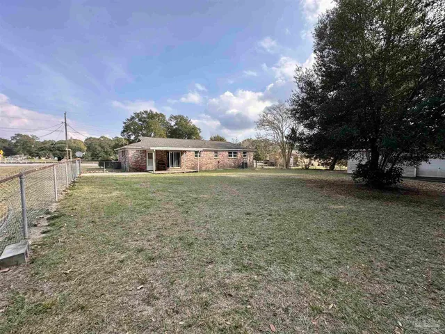 a view of a house with yard and sitting area