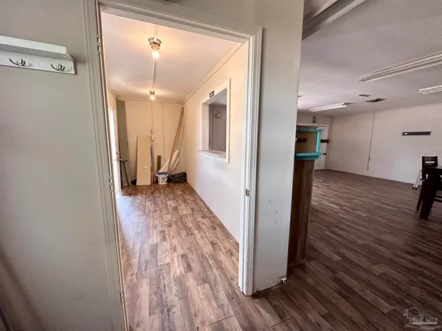 a view of a hallway with wooden floor and staircase