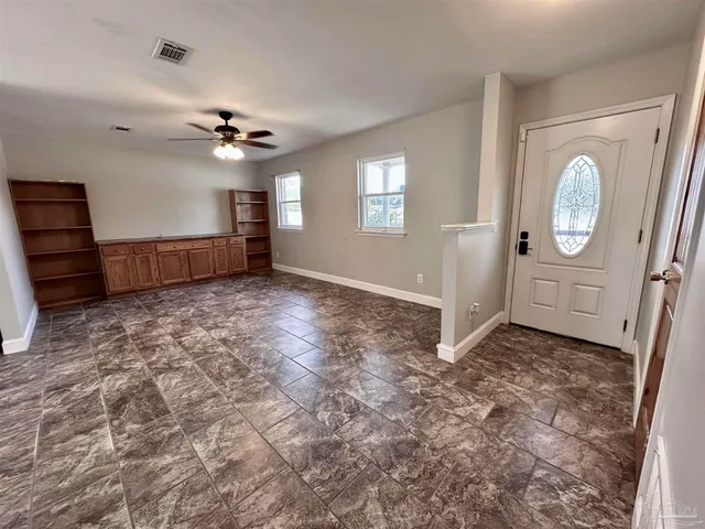 an empty room with windows and cabinet