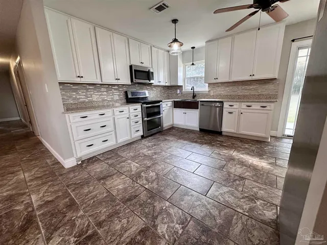 a kitchen with stainless steel appliances a stove a sink and a refrigerator