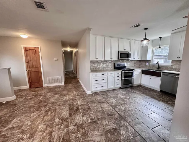 a large kitchen with cabinets and stainless steel appliances