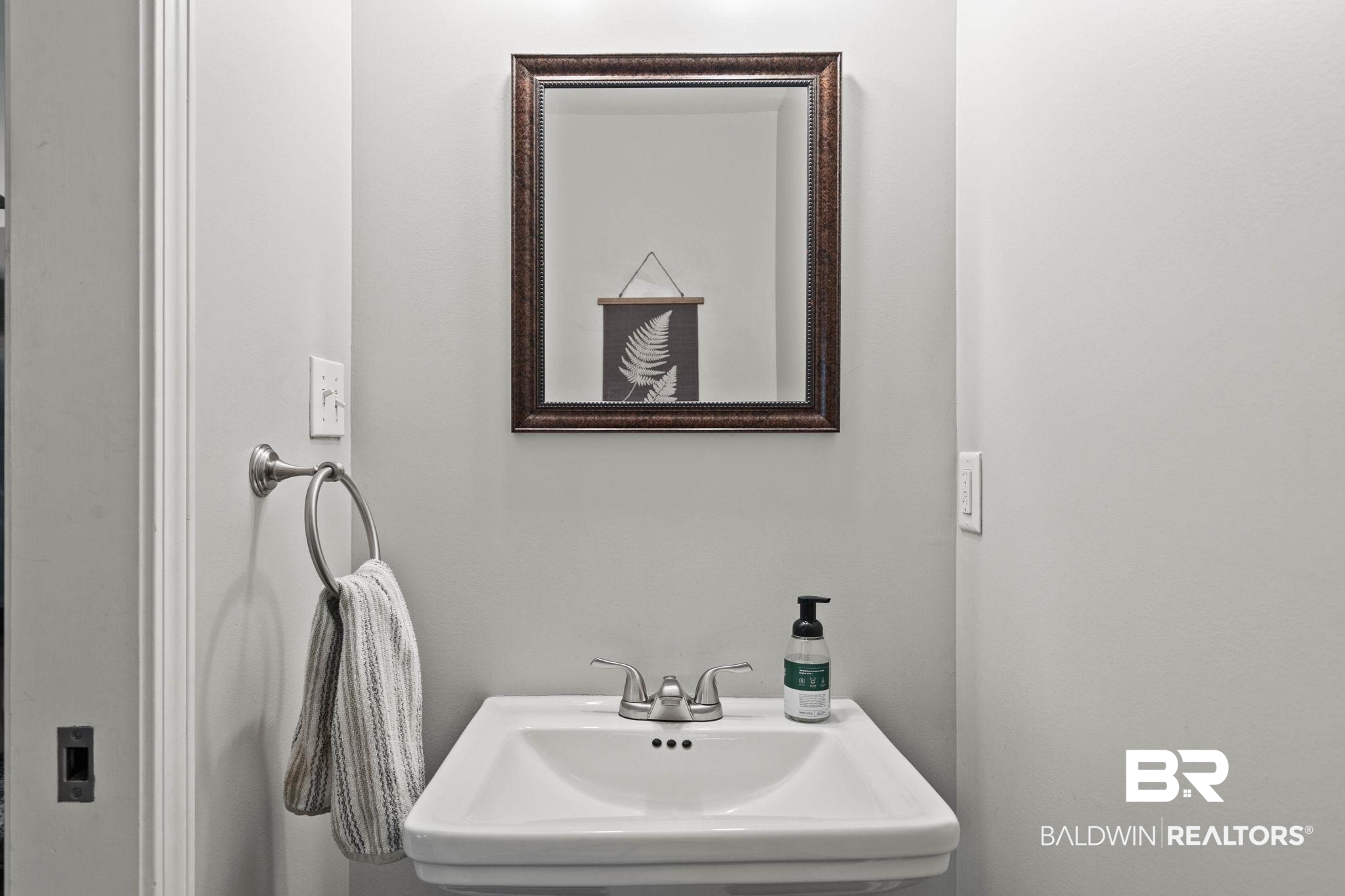 22810 High Ridge Road Fairhope, AL 36532 - Photo 32 of 78 Pedestal sink with a chrome two-handle faucet and an overhead framed mirror