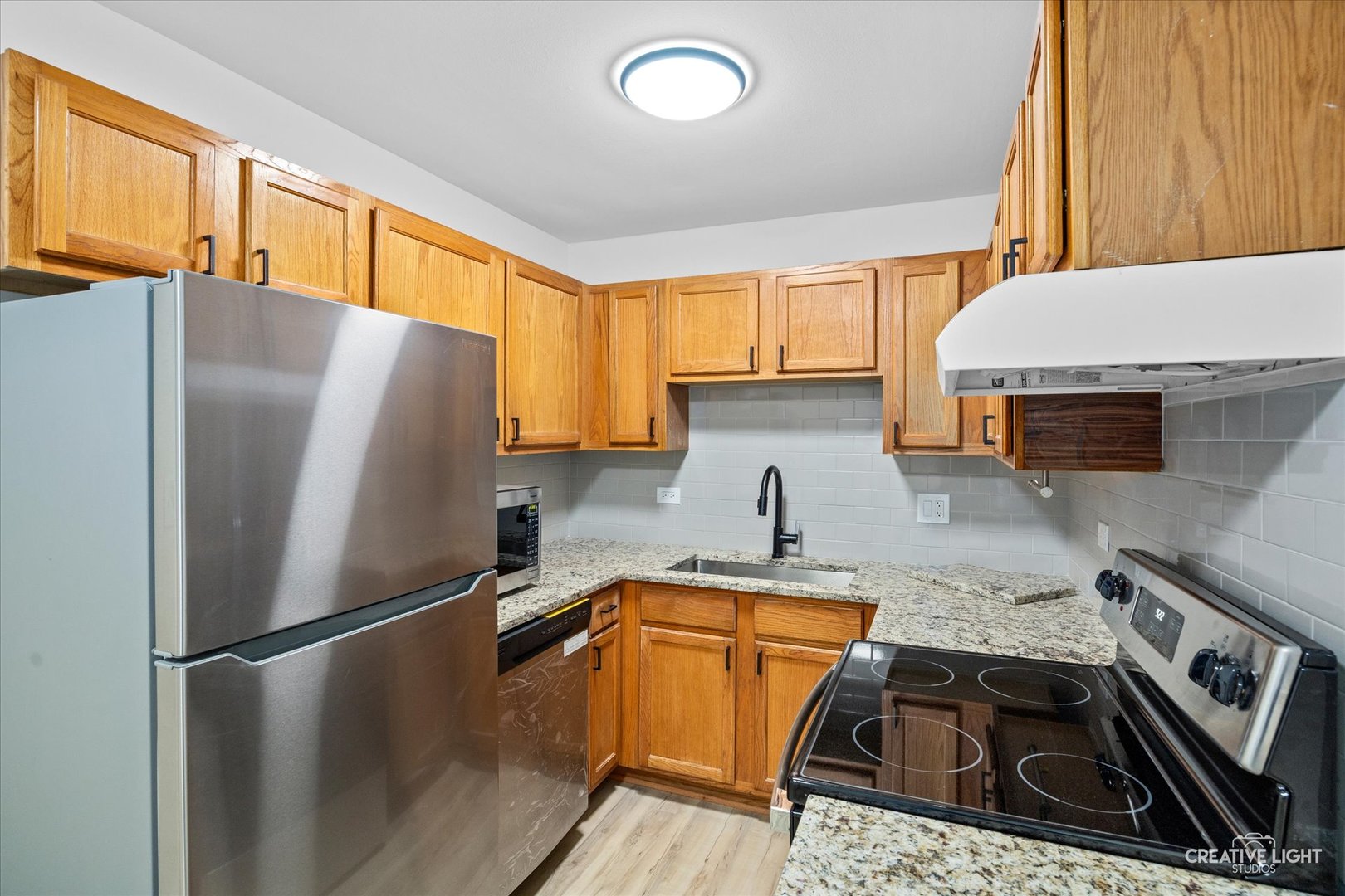 2600 Light Road, Unit 106 Oswego, IL 60543 - Photo 7 of 12 a kitchen with a refrigerator a sink and cabinets