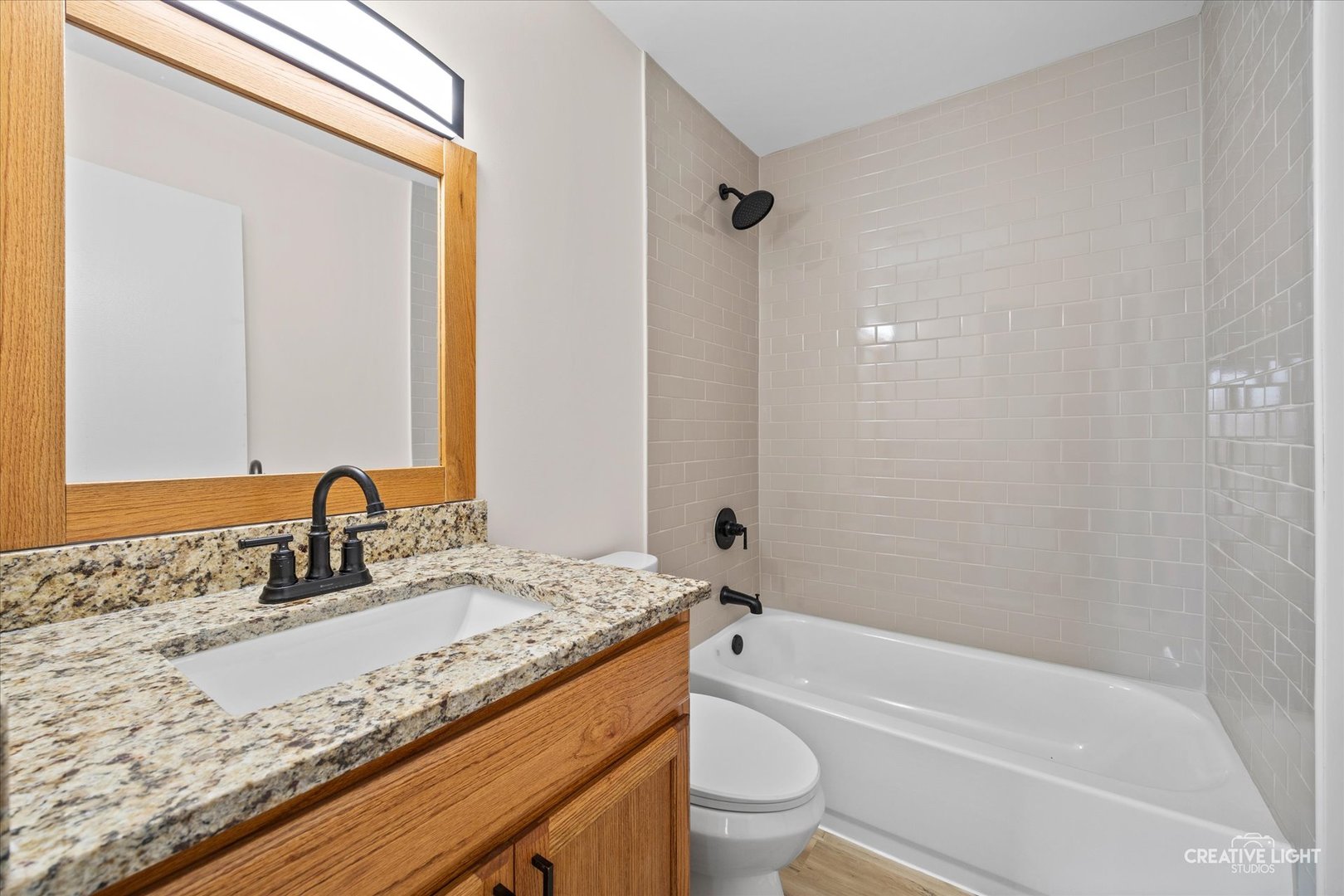 2600 Light Road, Unit 106 Oswego, IL 60543 - Photo 8 of 12 a bathroom with a granite countertop sink a toilet and bathtub
