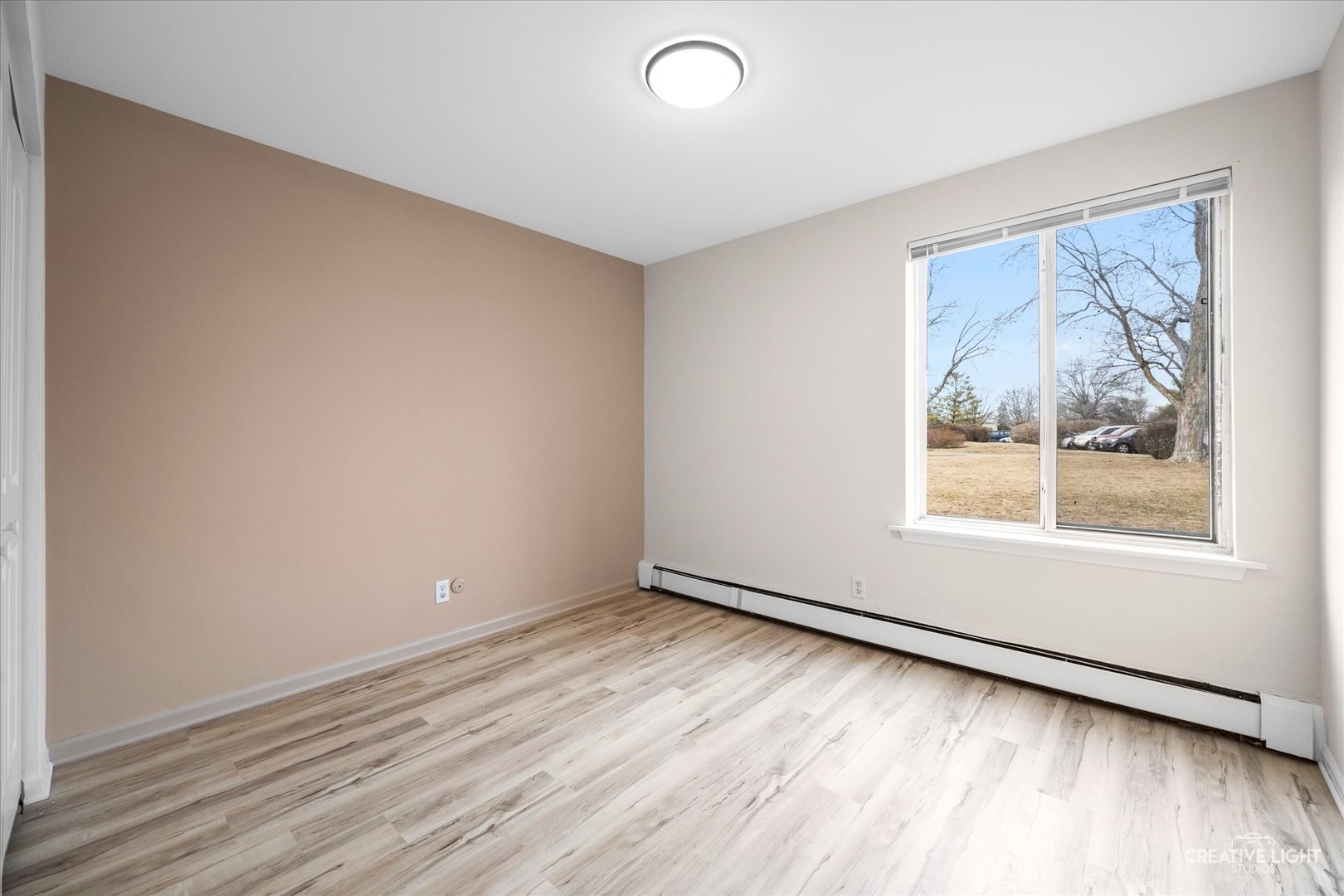 2600 Light Road, Unit 106 Oswego, IL 60543 - Photo 9 of 12 a view of an empty room with wooden floor and a window