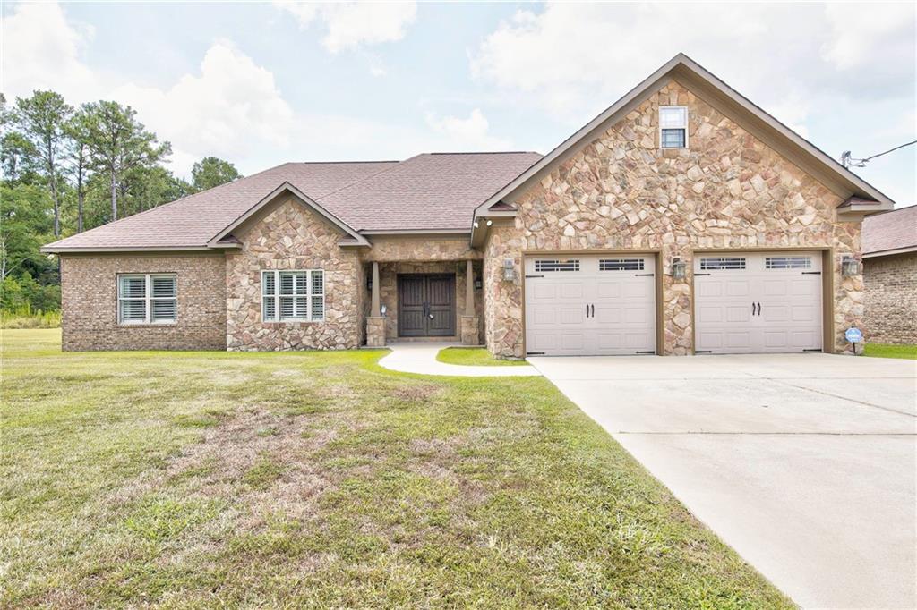611 Padgetts Road Opelika, AL 36804 - Photo 4 of 64 Stone and brick exterior with a two-car garage, concrete driveway, and a curved walkway to the entry