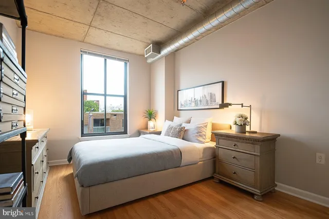 a bedroom with a bed and a flat tv screen on a dresser