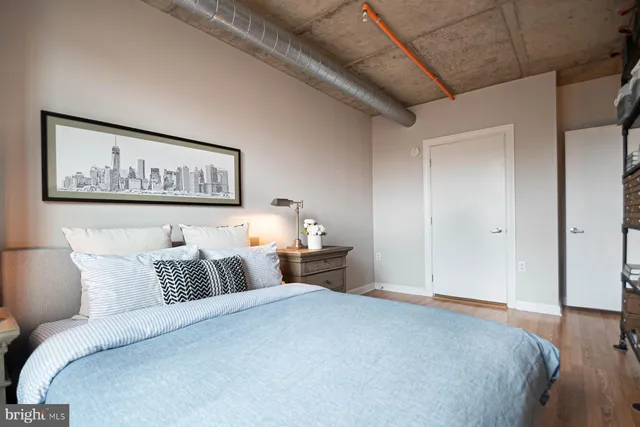 a bedroom with a large bed and paintings on the wall