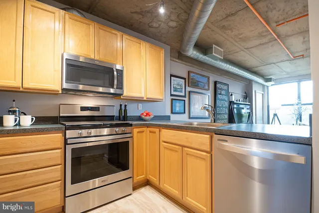 a kitchen with stainless steel appliances granite countertop a stove a sink and a microwave