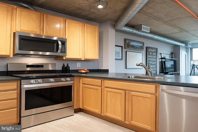 a kitchen with stainless steel appliances granite countertop a stove microwave and sink