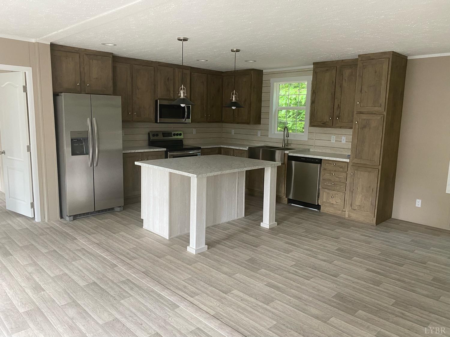 4006 Red House Road Appomattox, VA 24522 - Photo 7 of 11 a kitchen with stainless steel appliances granite countertop a stove a refrigerator and a microwave