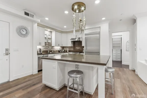 a kitchen with stainless steel appliances granite countertop a sink and a refrigerator