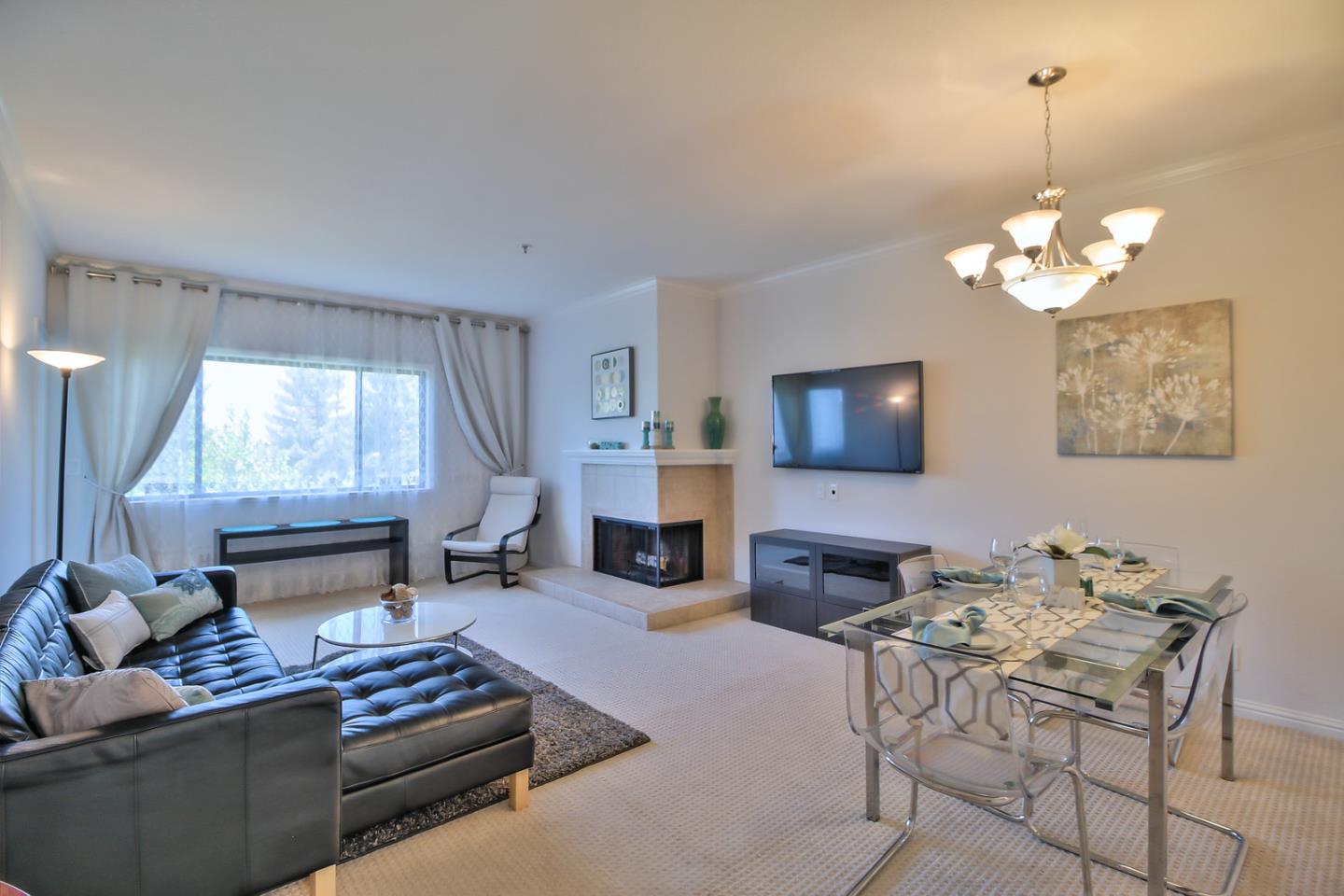 a living room with furniture a fireplace and a flat screen tv