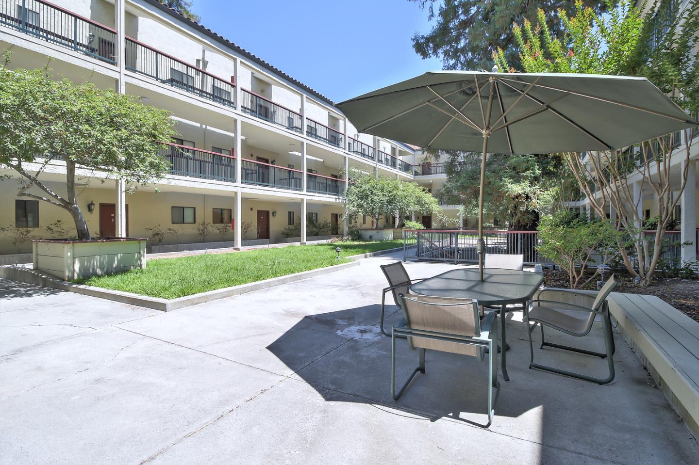 2200 Agnew Road, Unit 210 Santa Clara, CA 95054 - Photo 24 of 30 a view of a patio with a table and chairs under an umbrella