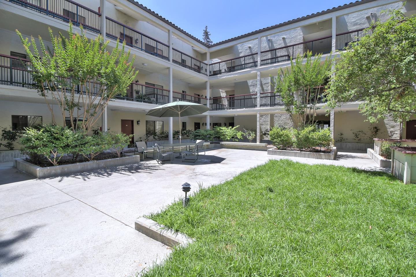 2200 Agnew Road, Unit 210 Santa Clara, CA 95054 - Photo 26 of 30 a view of a patio with a table and chairs under an umbrella
