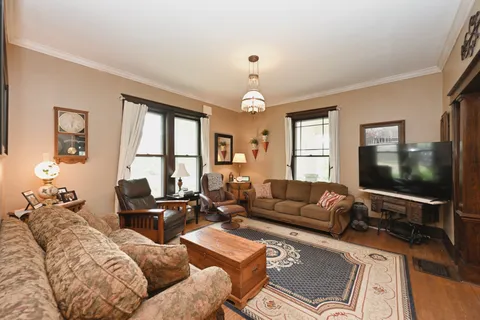 a kitchen with stainless steel appliances granite countertop a stove top oven a sink dishwasher and white cabinets with wooden floor