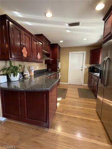 a kitchen with granite countertop stainless steel appliances and wooden cabinets