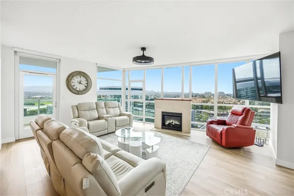 a living room with furniture a fireplace a clock and a large window