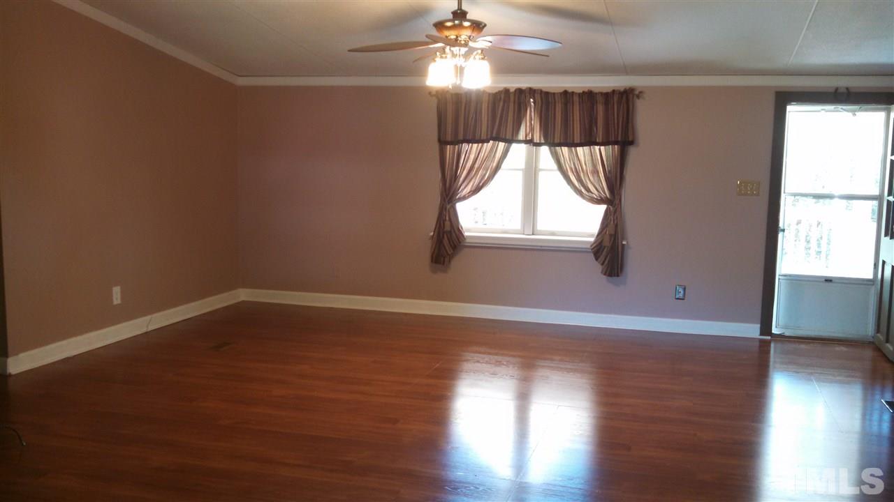 2001 Sanders Road Stem, NC 27581 - Photo 3 of 21 a view of an empty room with wooden floor and a window