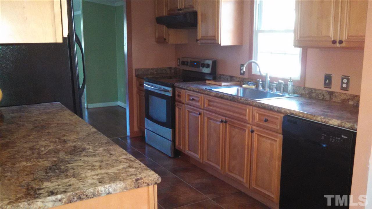 2001 Sanders Road Stem, NC 27581 - Photo 9 of 21 a kitchen with stainless steel appliances granite countertop a sink stove and cabinets