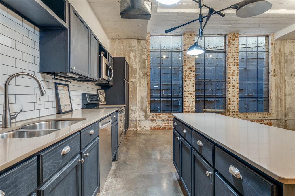 1122 Jackson Street, Unit 922 Dallas, TX 75202 - Photo 16 of 25 a kitchen with stainless steel appliances granite countertop a sink and cabinets