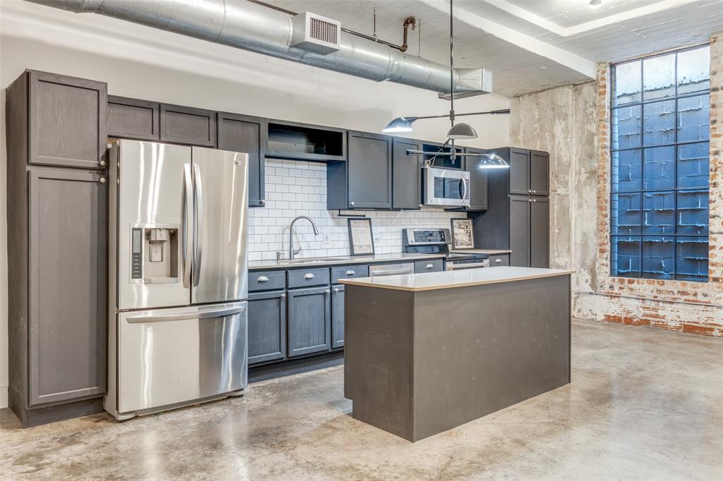 1122 Jackson Street, Unit 922 Dallas, TX 75202 - Photo 18 of 25 a kitchen with stainless steel appliances granite countertop a refrigerator and a sink