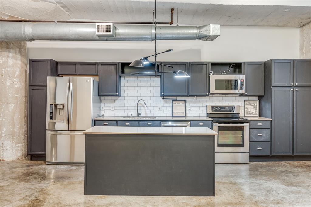 1122 Jackson Street, Unit 922 Dallas, TX 75202 - Photo 19 of 25 a kitchen with stainless steel appliances granite countertop a refrigerator a stove and a sink