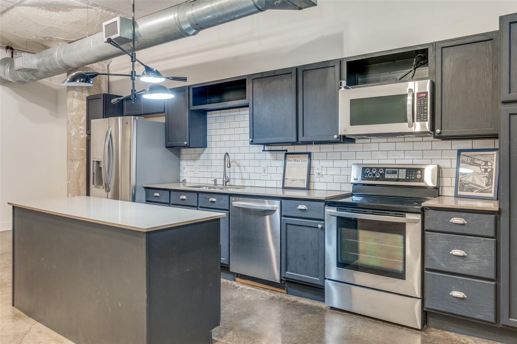 1122 Jackson Street, Unit 922 Dallas, TX 75202 - Photo 21 of 25 a kitchen with stainless steel appliances granite countertop a stove a sink and a microwave