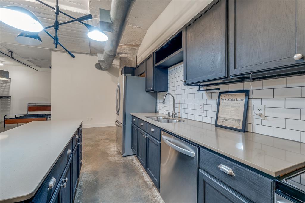 1122 Jackson Street, Unit 922 Dallas, TX 75202 - Photo 23 of 25 a kitchen with stainless steel appliances granite countertop a sink a stove and a microwave
