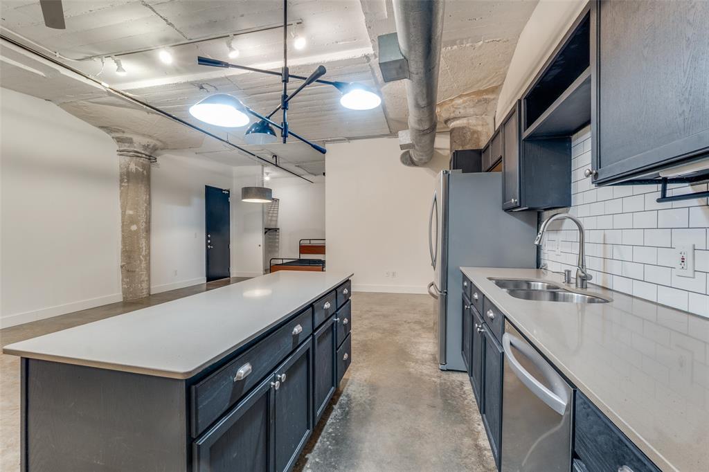1122 Jackson Street, Unit 922 Dallas, TX 75202 - Photo 24 of 25 a kitchen with a stove a sink and a refrigerator