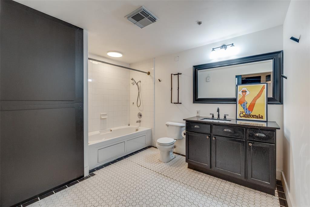 1122 Jackson Street, Unit 922 Dallas, TX 75202 - Photo 9 of 25 a bathroom with a tub sink toilet and mirror