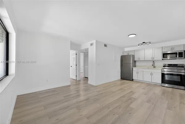 a view of kitchen with stainless steel appliances refrigerator stove microwave and cabinets